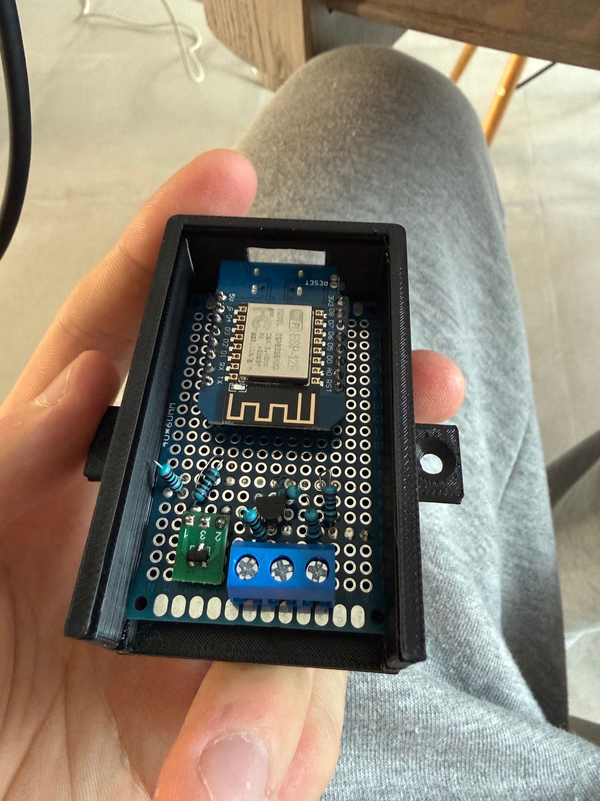 Een zelfgebouwd bordje met een wifi-chip in een zwarte, 3D-geprinte behuizing.